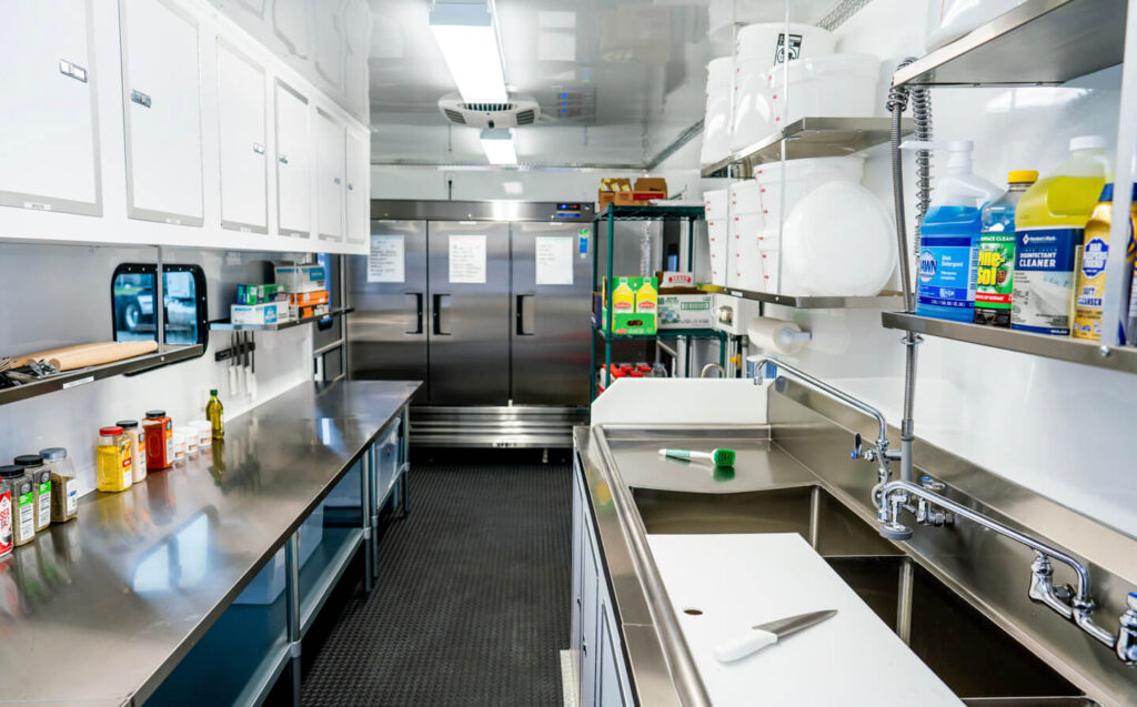 A well-equipped kitchen with stainless steel appliances and a sink, suitable for remote site catering base camp operations.